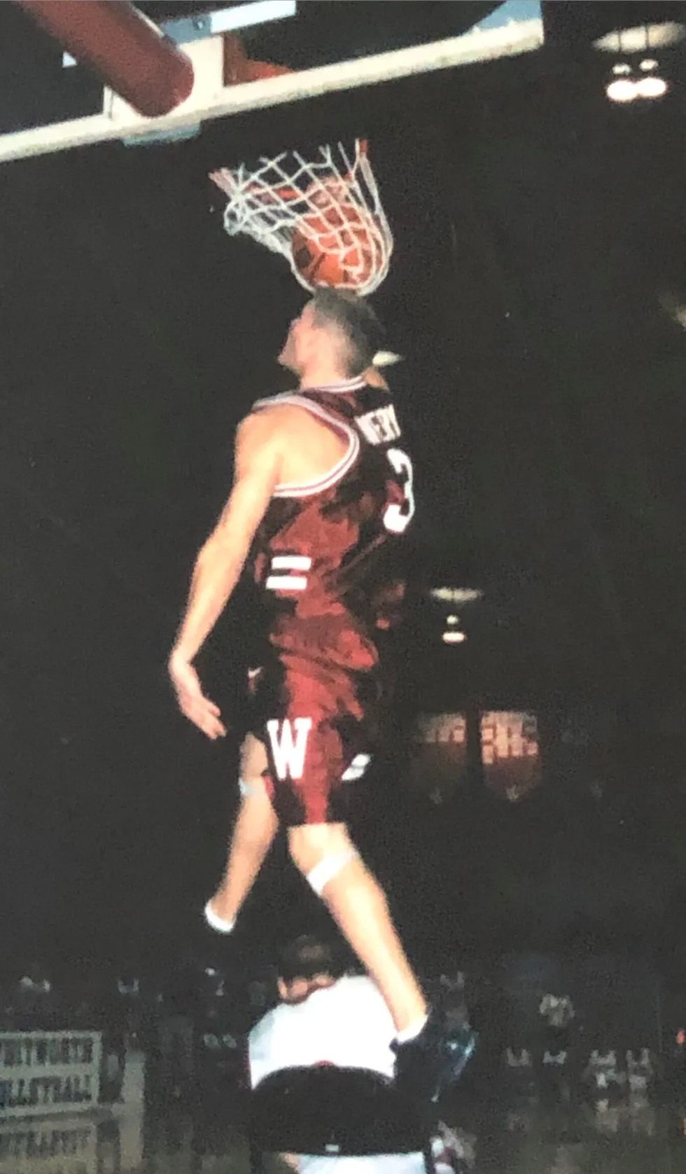 Eric dunks over a seated teammate in a dunk competition at Whiteworth University